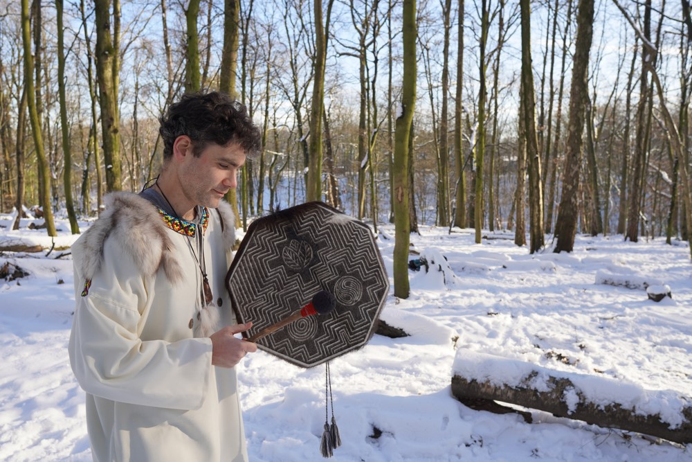 A person holding a shamanic drum.